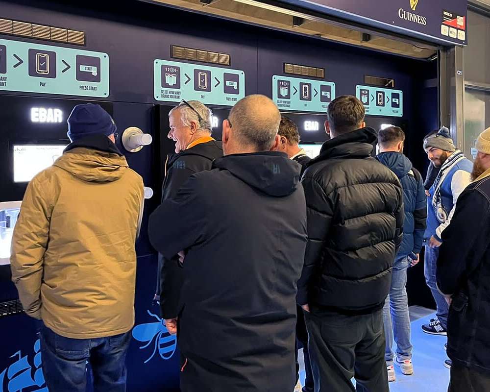 Football fans using the EBar automated beer kiosk in a 4-unit Beerwall setup