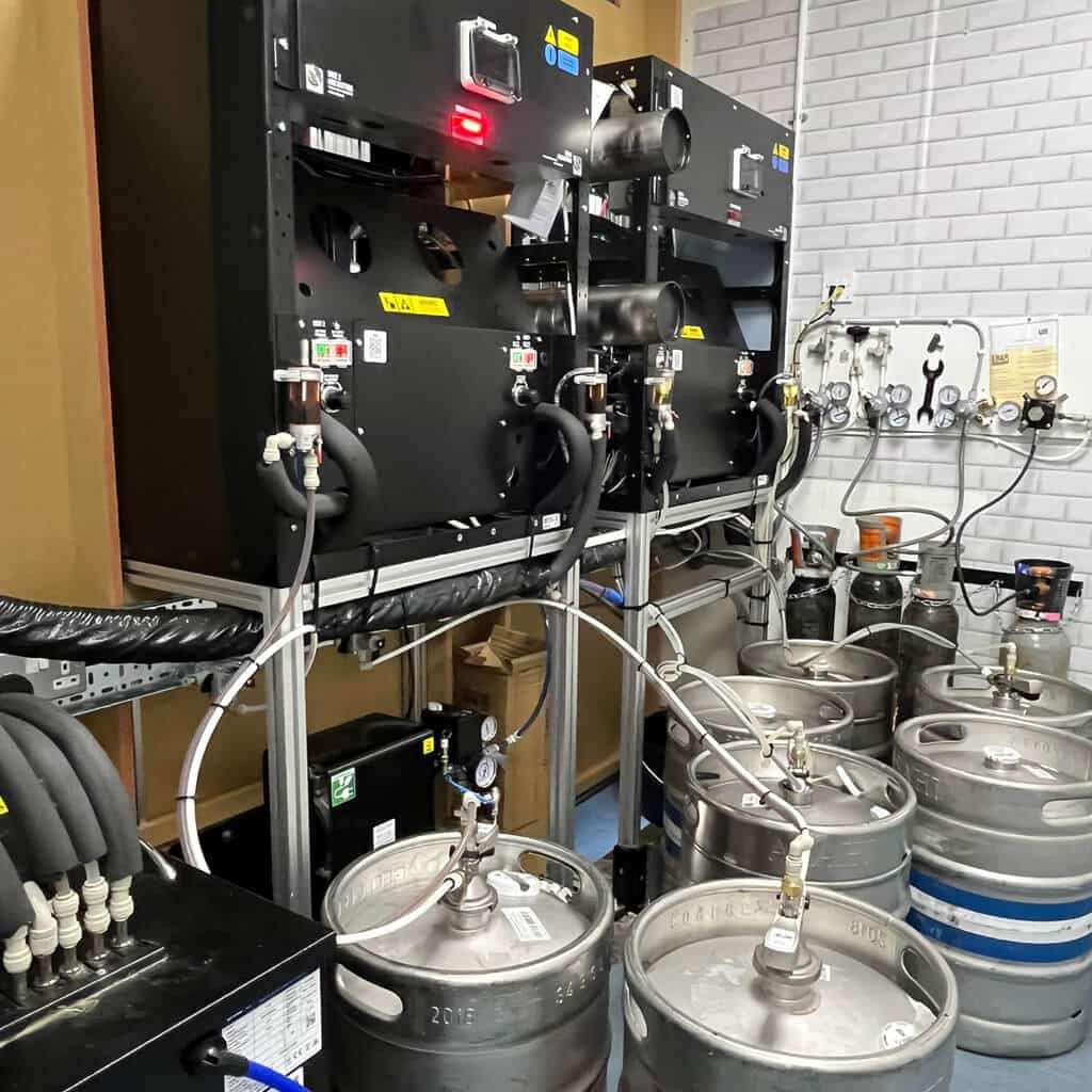 Behind the scenes of a Beerwall, with two EBar units built into the wall, and several kegs stored behind them