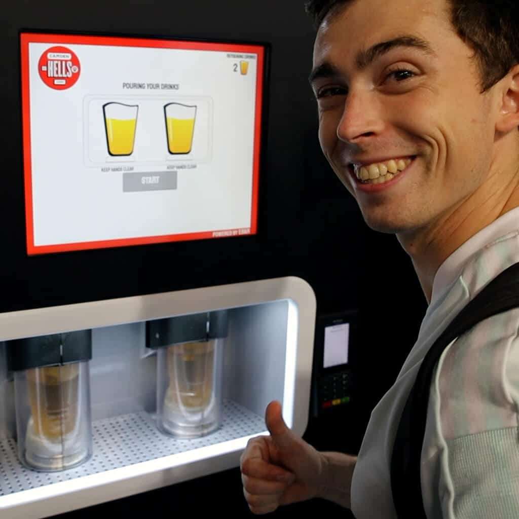 A happy man smiles and raises his thumb as his two pints of lager pour in the EBar unit in front of him