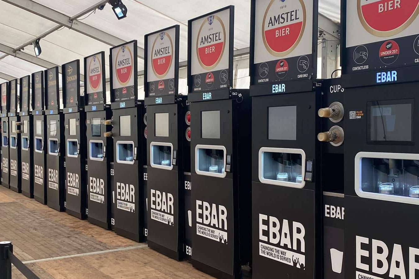 A row of 16 mobile EBars on a marquee, serving Amstel Lager and Strongbow cider